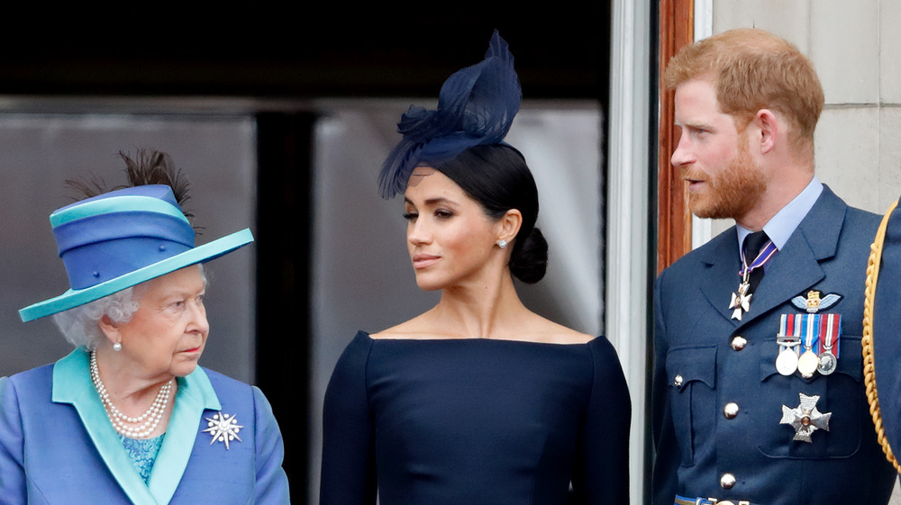 La regina Elisabetta guarda severamente Meghan e Harry