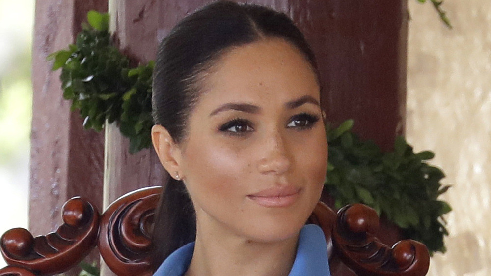 Meghan Markle indossa una coda di cavallo e un vestito blu