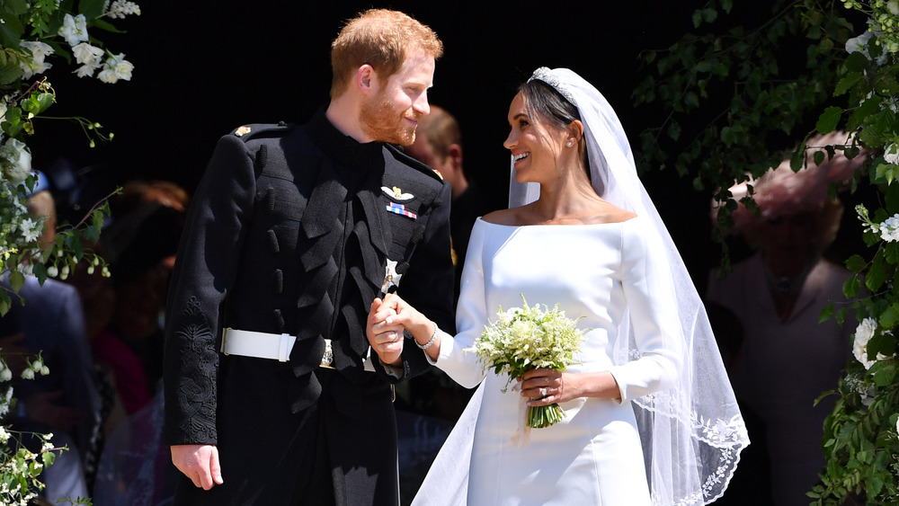 Il principe Harry e Meghan Markle sorridono e tengono i ghands al loro matrimonio 