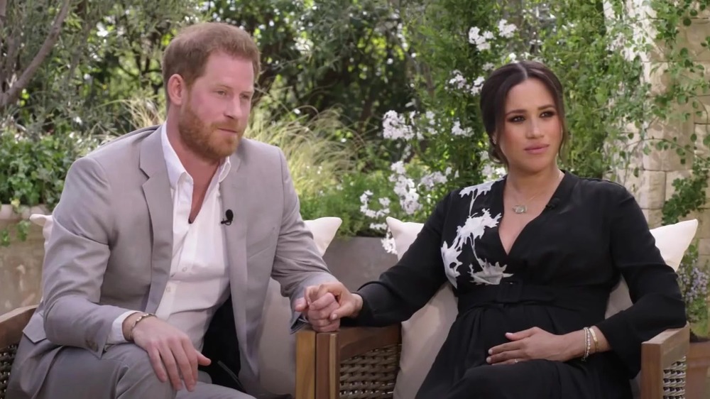 Il principe Harry e Meghan Markle si tengono per mano durante la loro esclusiva intervista a Oprah Winfrey 