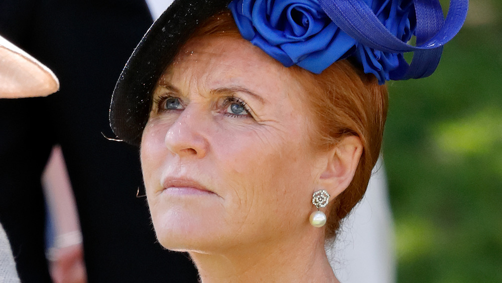 Sarah Ferguson che guarda il cielo, con indosso un cappello blu