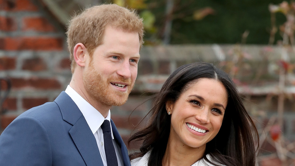 Il principe Harry e Meghan Markle sorridono per le telecamere