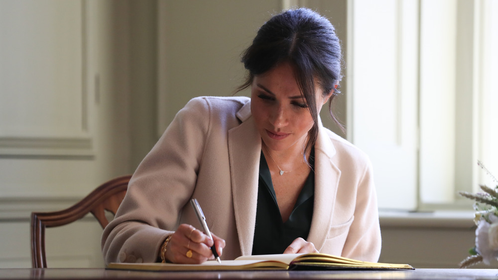 Meghan Markle scrive a una scrivania