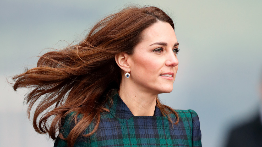 Kate Middleton sorride con i capelli mossi dal vento