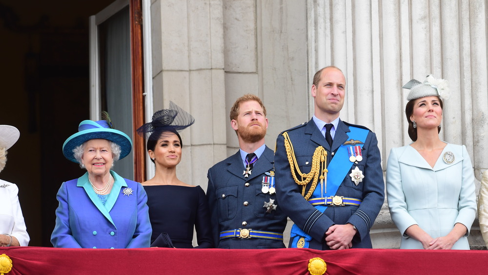 La regina Elisabetta, Meghan Markle, il principe Harry, il principe William, Kate Middleton sorridono su un balcone 