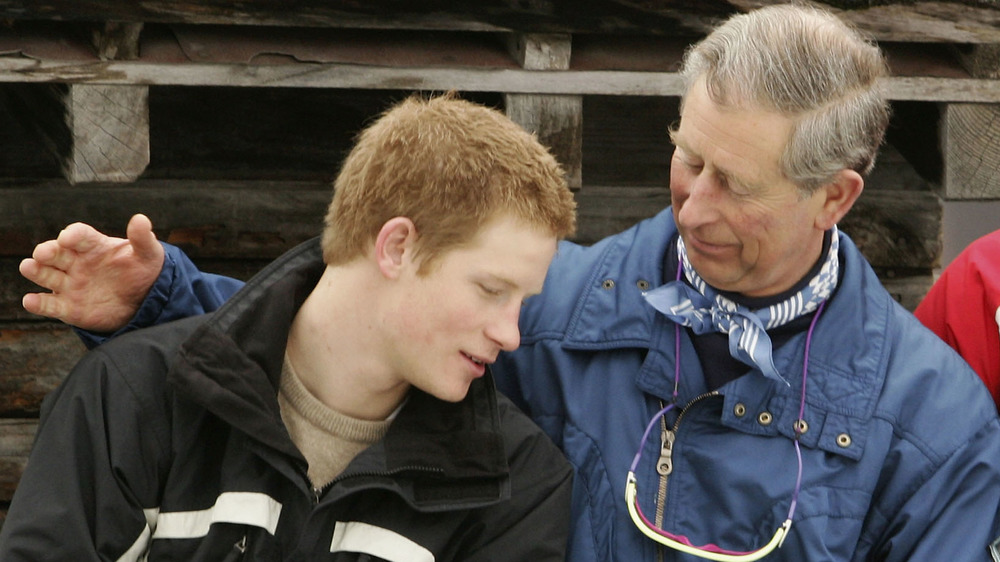 Un giovane principe Harry che riceve una pacca sulla spalla dal principe Carlo