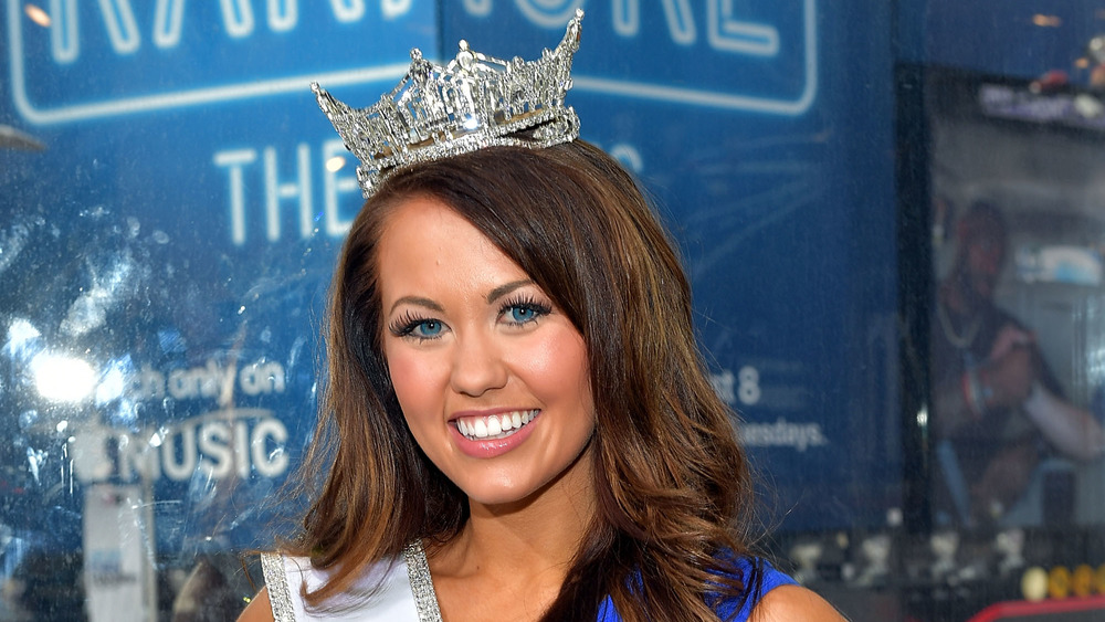 Cara Mund sorride nella sua corona e fascia di Miss America