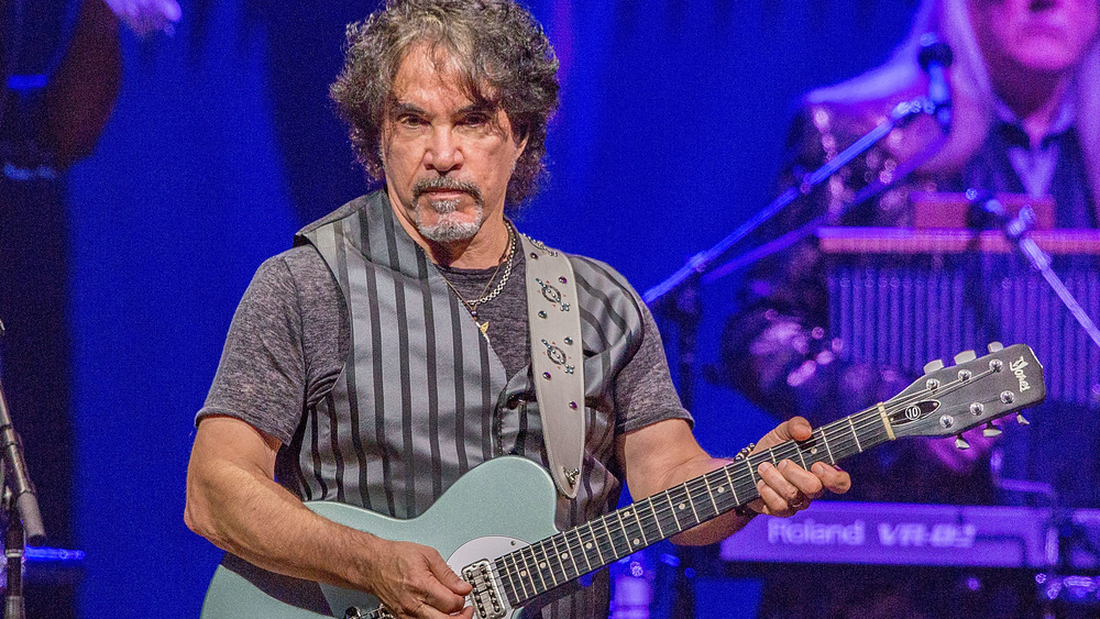 Il chitarrista di Hall & Oates John Oates sembra severo e suona la chitarra 