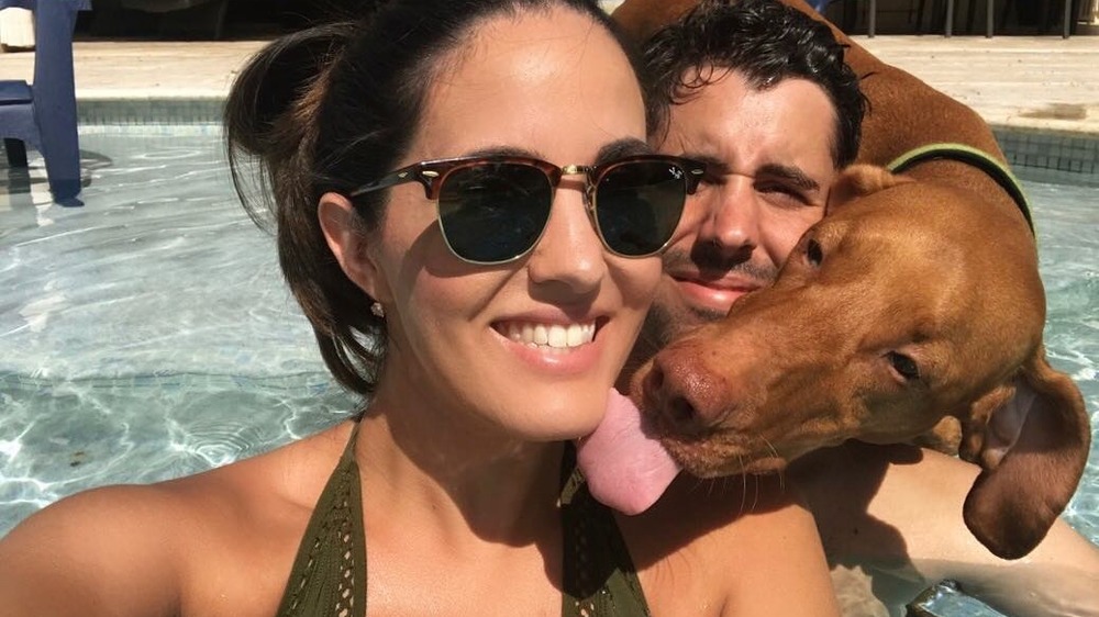 La dottoressa Jackie Duenas e suo marito con un cane in piscina 