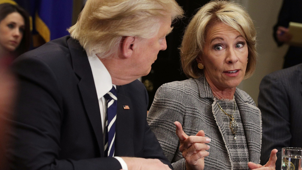 Il presidente Trump guarda una Betsy DeVos puntata il dito