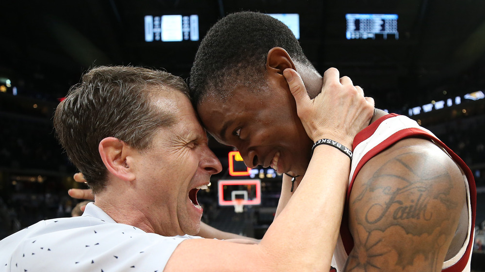 Eric Musselman che abbraccia il suo giocatore di basket