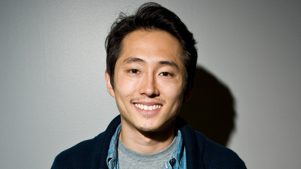 Steven Yeun sorride a una mostra di fumetti