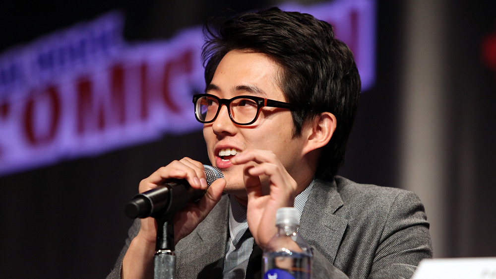 Steven Yeun parla al microfono al Comic Con di New York