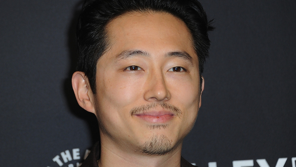 Steven Yeun sorrideva