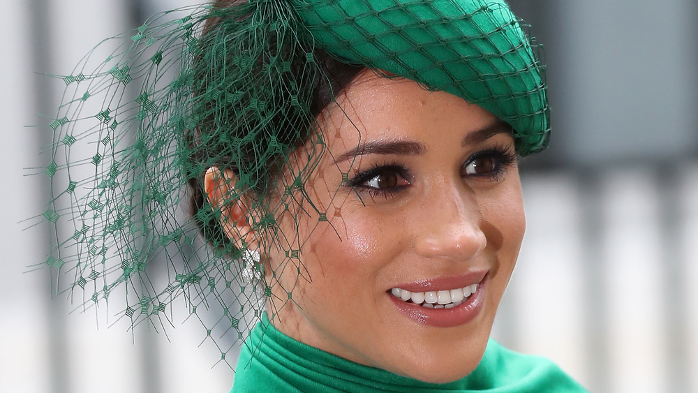 Meghan Markle sorride con il cappello verde