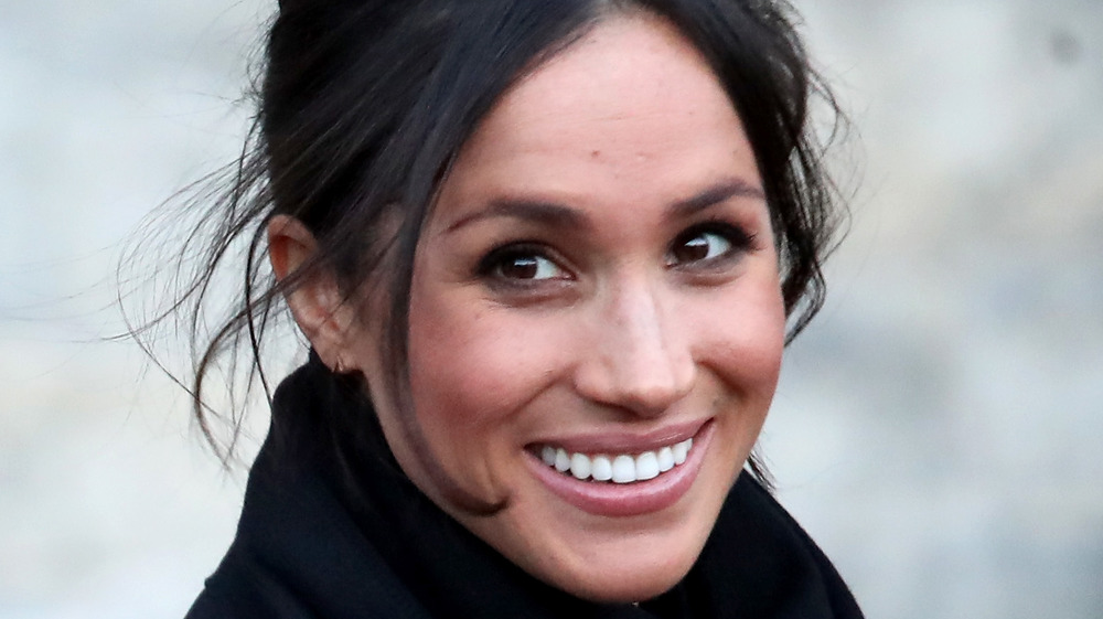 Meghan Markle sorride con i capelli raccolti