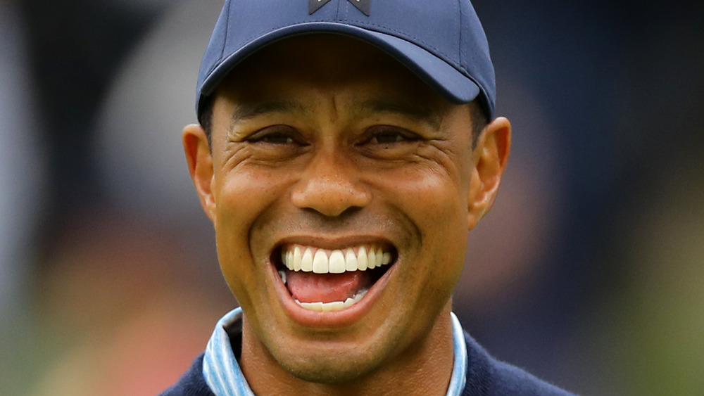 Tiger Woods ride mentre gioca a golf