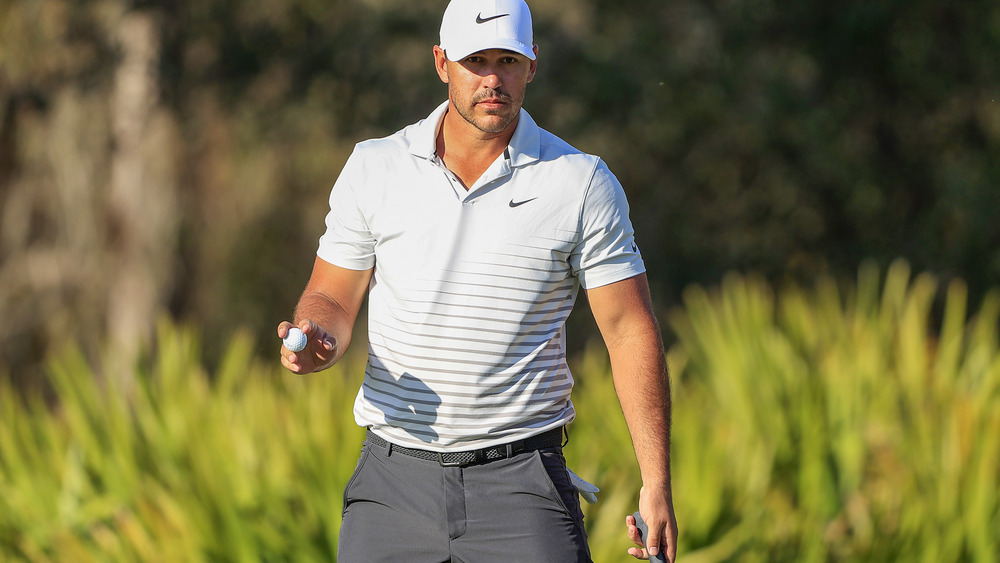 Brooks Koepka cammina con la pallina da golf in mano