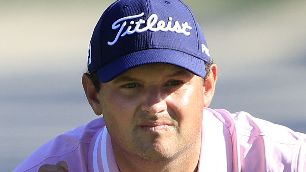 Patrick Reed accovacciato sul campo da golf