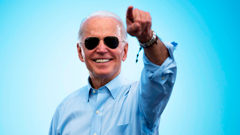 Joe Biden sorride e indica 