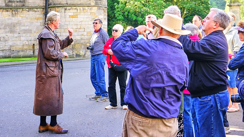 Una guida turistica offre un tour a Holyroodhouse