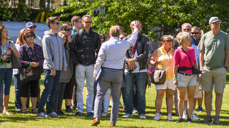 Una guida turistica di Buckingham Palace con un gruppo di turisti