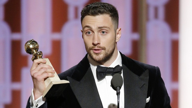 Aaron Taylor-Johnson con in mano il suo trofeo Golden Globe