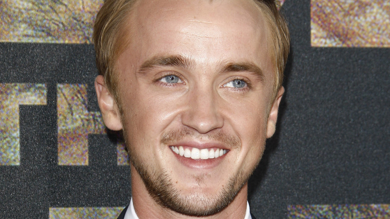 Tom Felton sorride