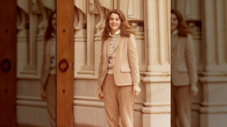 Una giovane Melinda Gates davanti a pilastri e statue 