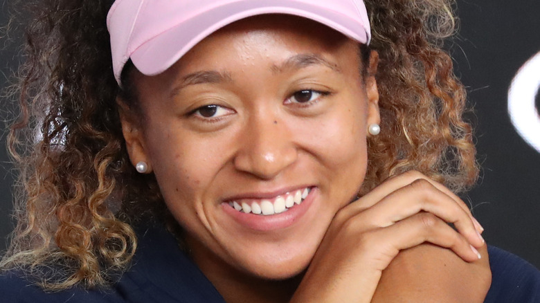 naomi osaka sorridente con le mani sul viso