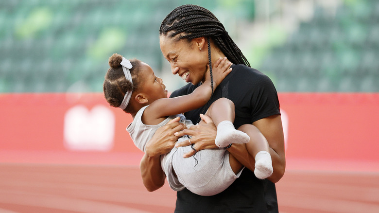 Allyson Felix, con in braccio sua figlia Camryn sul campo di atletica