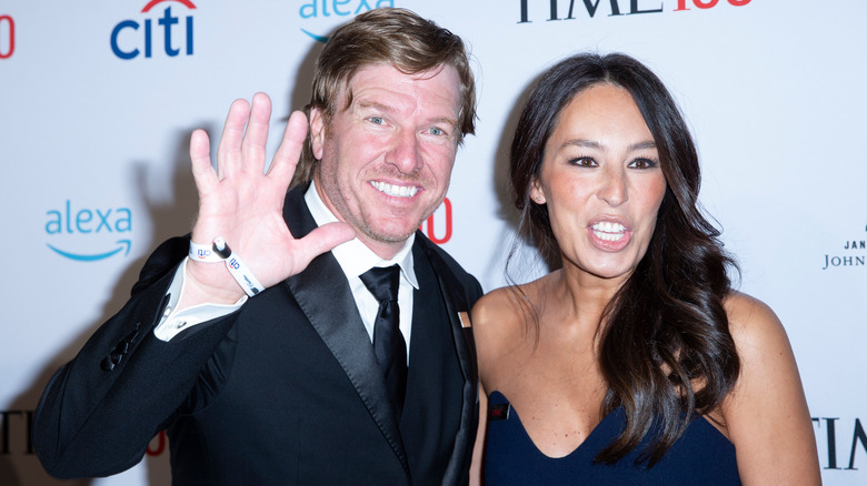 Chip Gaines che saluta accanto a una sorridente Joanna Gaines 