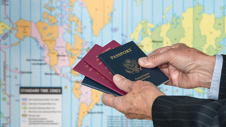 Mani che tengono i passaporti del Regno Unito e degli Stati Uniti