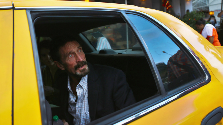 John McAfee in taxi giallo