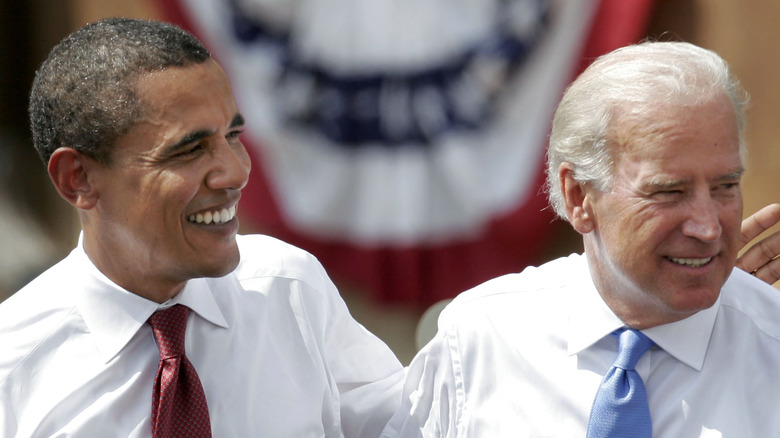 Barack Obama e Joe Biden sorridono sul palco