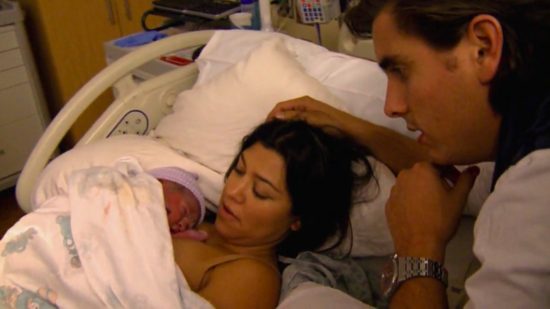 Kourtney Kardashian tiene in braccio un neonato con Scott Disick