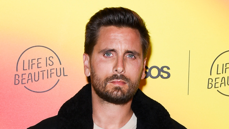 Scott Disick in un cappotto, guardando la telecamera