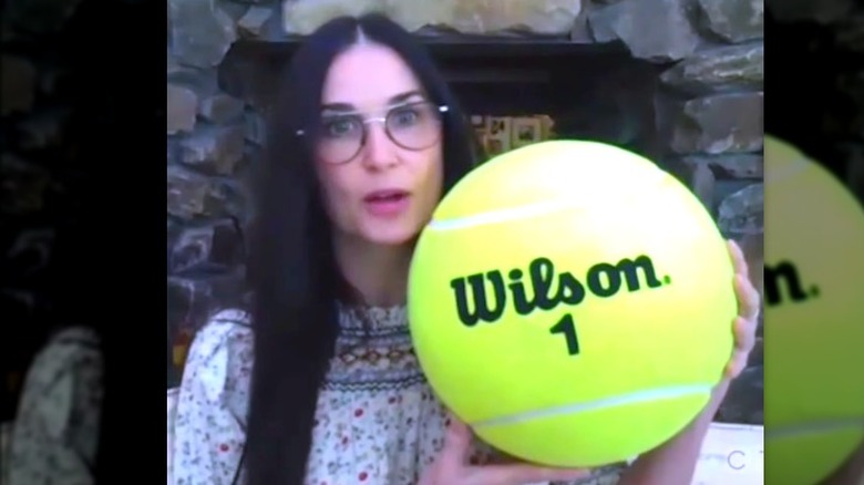 Demi Moore con in mano una pallina da tennis gigante