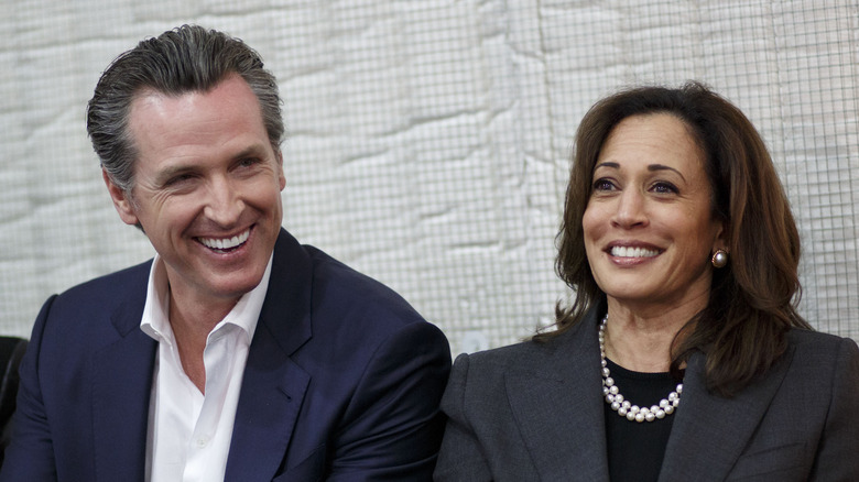 Gavin Newsom e Kamala Harris sorridono