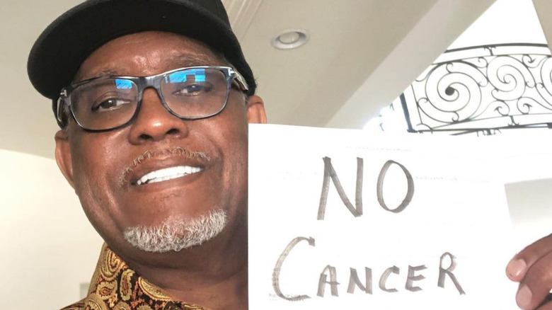 Gregg Leakes con un cartello con la scritta "No Cancer"