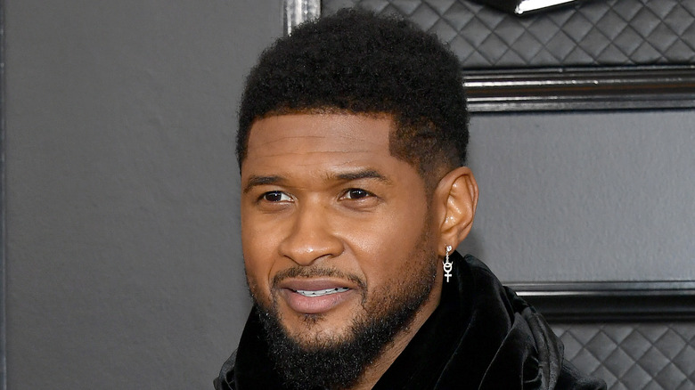 Usher sorride davanti a uno sfondo nero