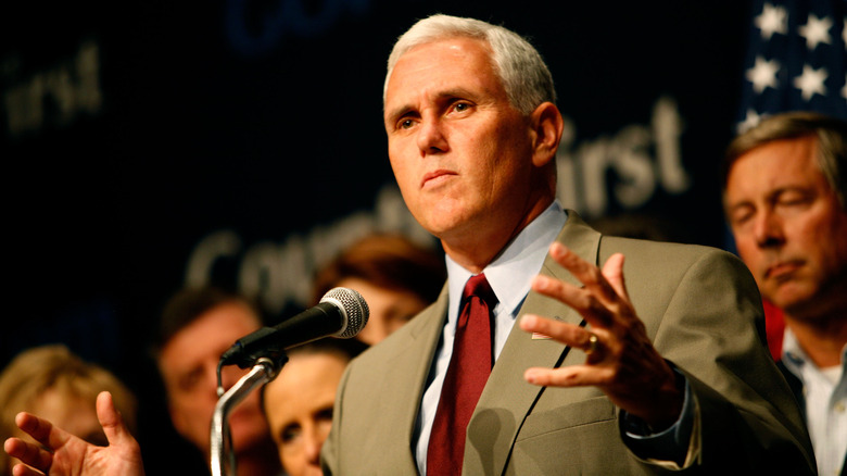 Mike Pence parla sul podio a braccia aperte