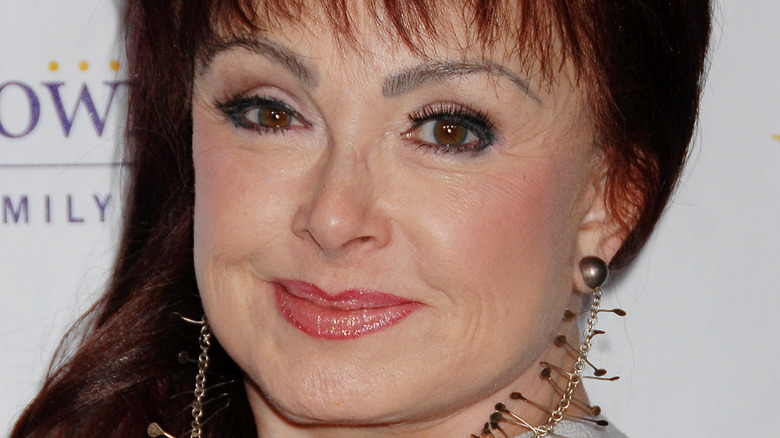 Naomi Judd indossa orecchini di metallo 