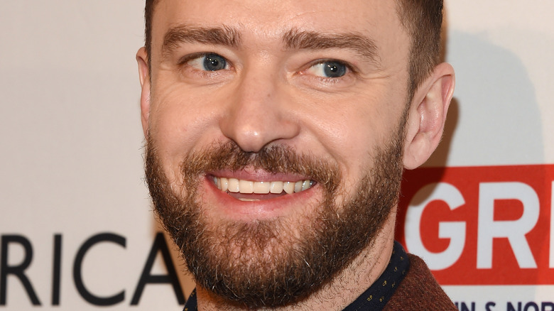 Justin Timberlake sorride con un abito marrone