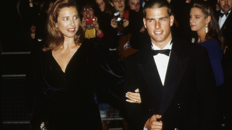 Mimi Rogers tiene il braccio di Tom Cruise nel 1989