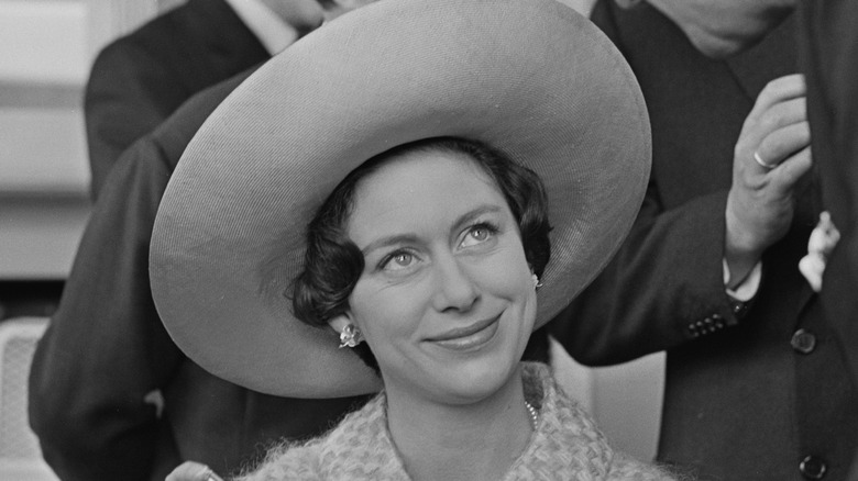 La principessa Margaret a un evento con indosso un grande cappello e sorridente