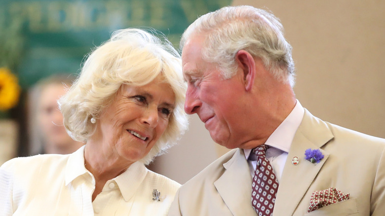 Re Carlo III e Camilla a un evento, sorridendo da vicino