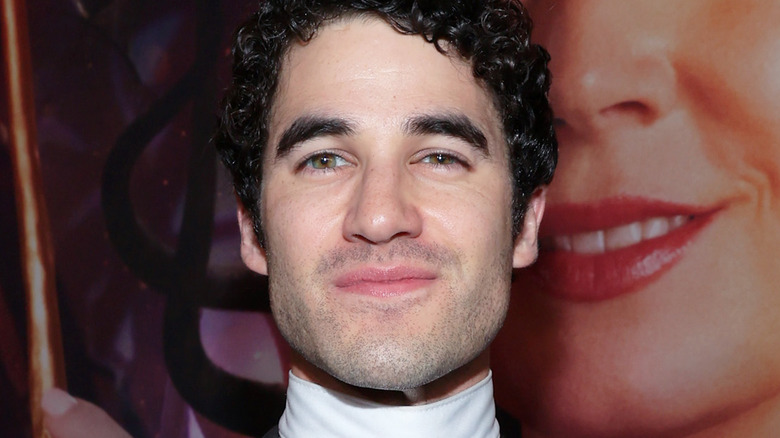Darren Criss ricci capelli neri occhi verdi nocciola barba 5 in punto ombra bocca chiusa sorriso