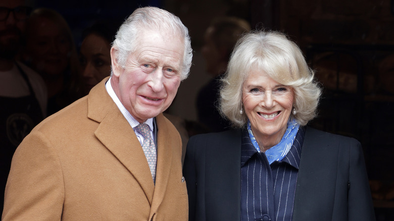 Re Carlo e la regina Camilla sorridono