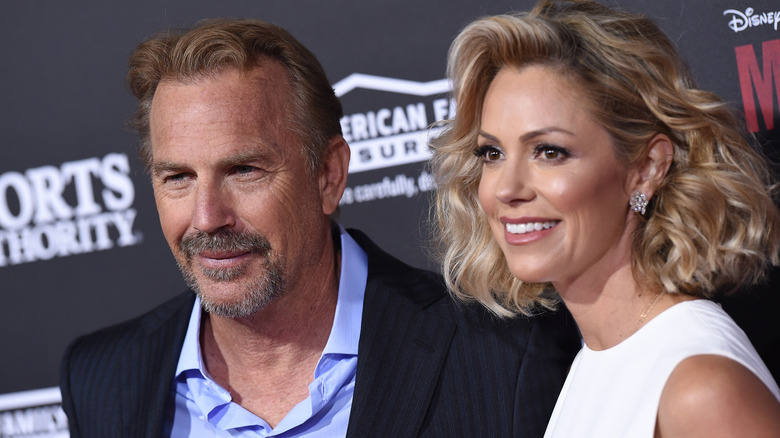 Kevin Costner e Christine Baumgartner sorridono